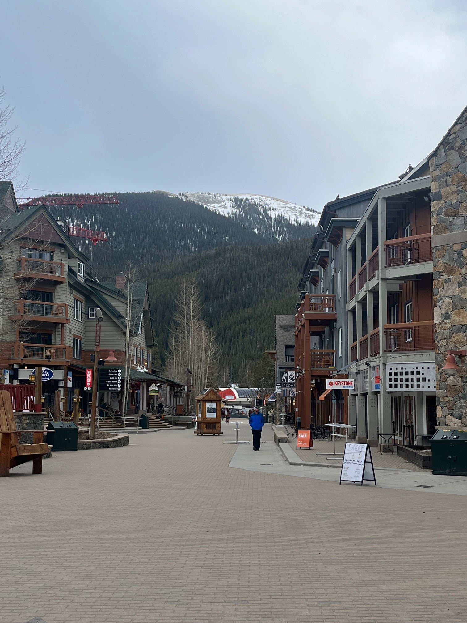 Pedestrian village street in Keystone with shops and lodges beneath a snow-dusted mountain