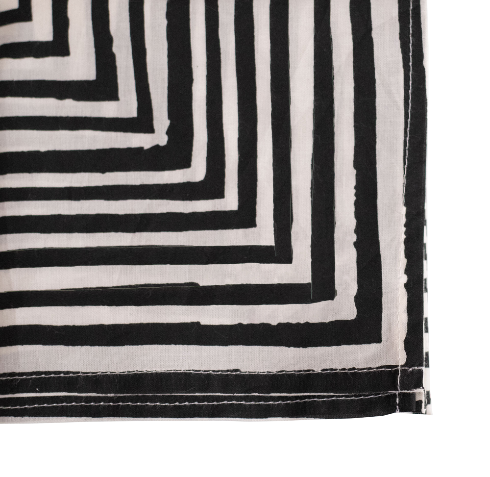 Corner of black-and-white fabric with concentric rectangular stripe pattern