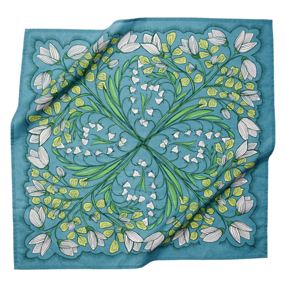Blue square scarf with symmetrical green stems, white bell-shaped flowers and tulip-like blooms in a floral pattern.