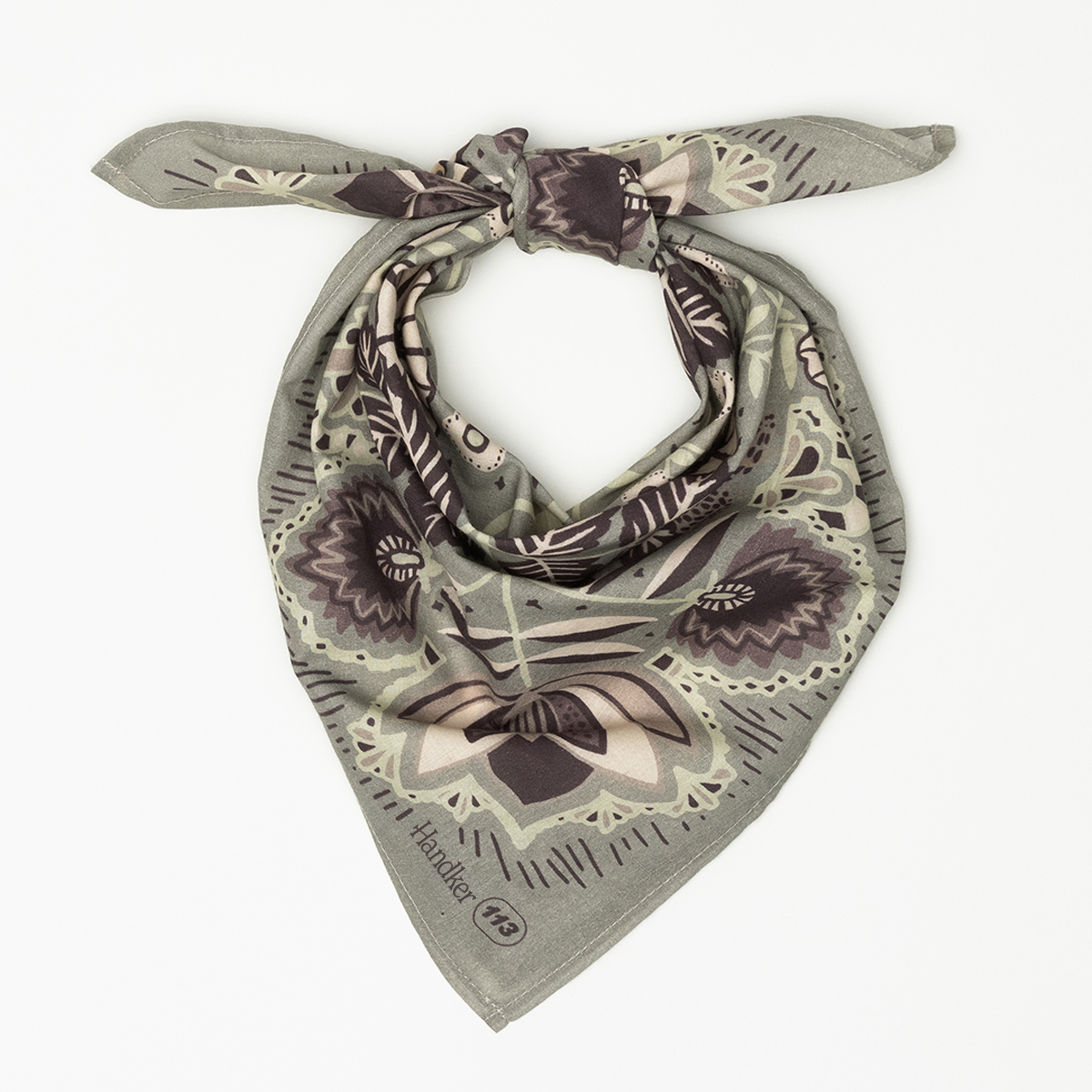Top-down view of No. 113 Esther bandana showcasing muted gray, cream, and purple floral paisley print on white background