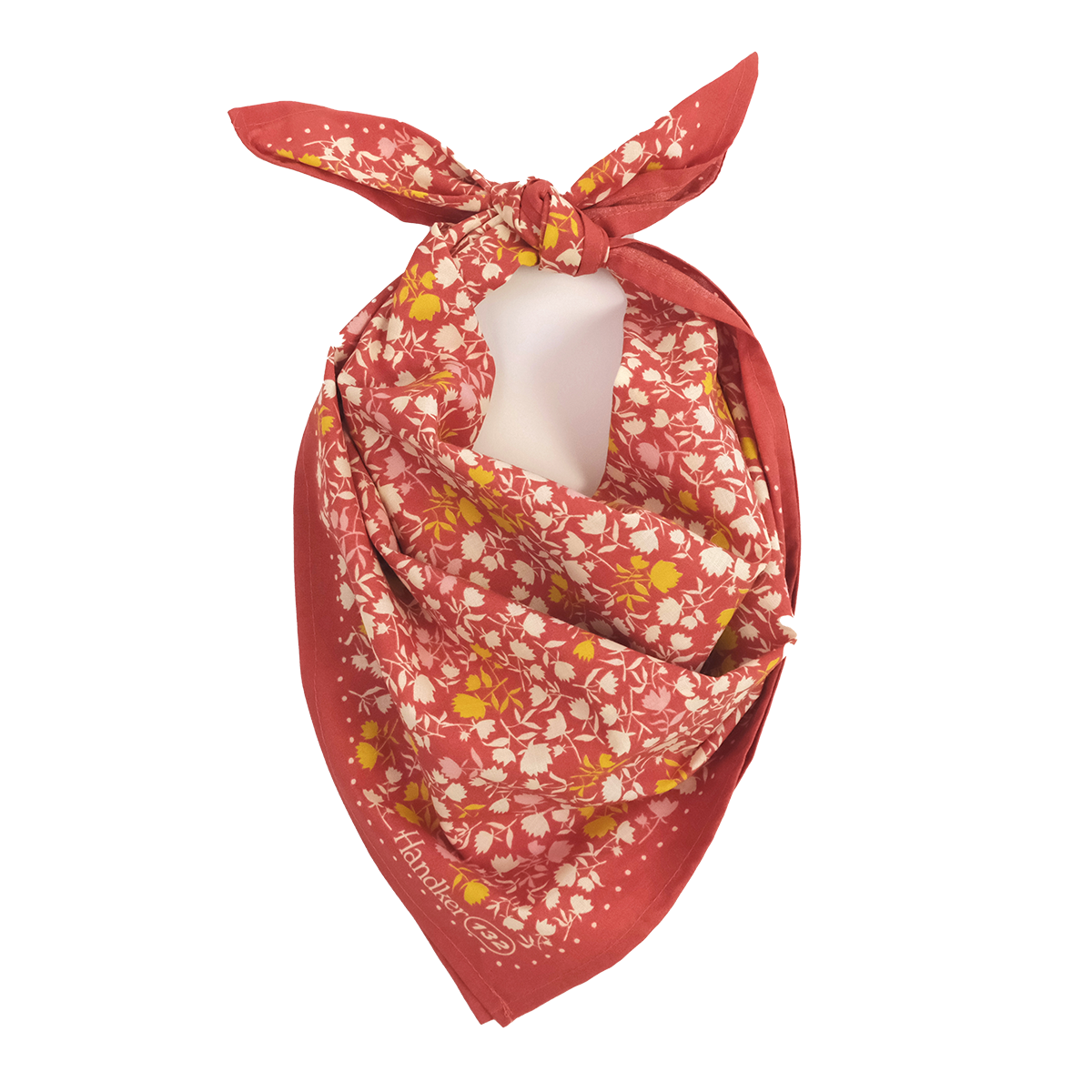 Coral-red bandana with small white and yellow flowers, folded into a triangle and tied at the top