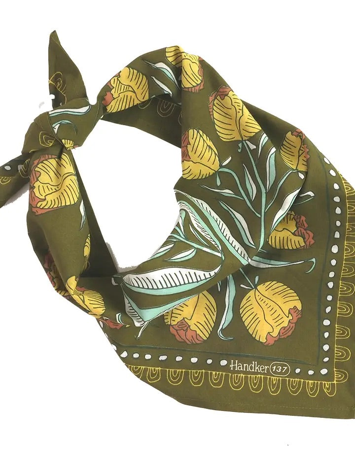 Front view of folded Adele bandana showcasing olive green background with yellow floral print and tied corner on white background