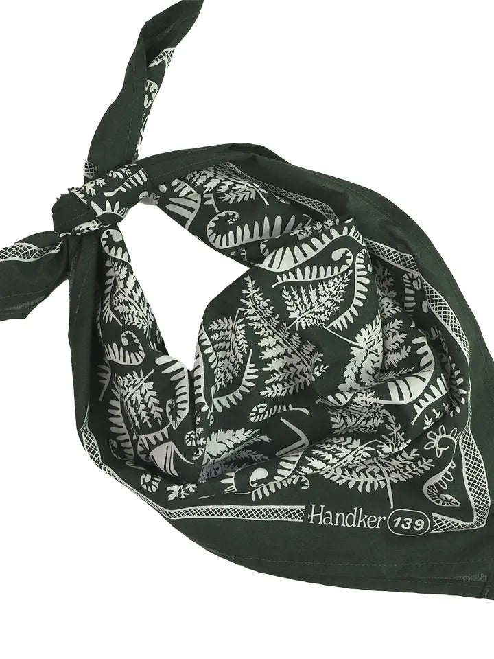 Folded dark forest green bandana tied at one corner showing white fern print and Handker 139 logo on white background