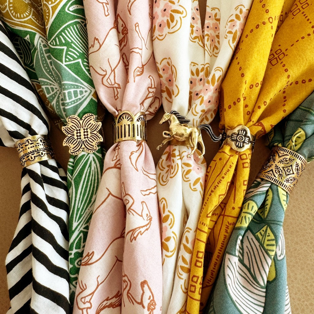 Colorful patterned silk scarves knotted with decorative gold-tone and jeweled rings