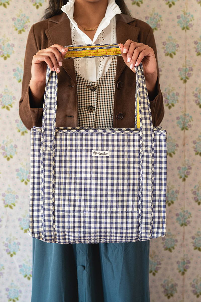 Front view of Teddy Quilted Tote showing quilted navy and cream gingham fabric and wide double shoulder straps