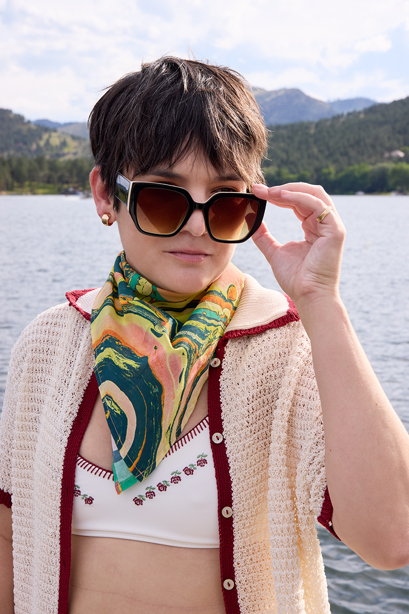 Front view of No. 140 Marble Bandana tied at the neck showing green and pink marble print on a model at a lakeside