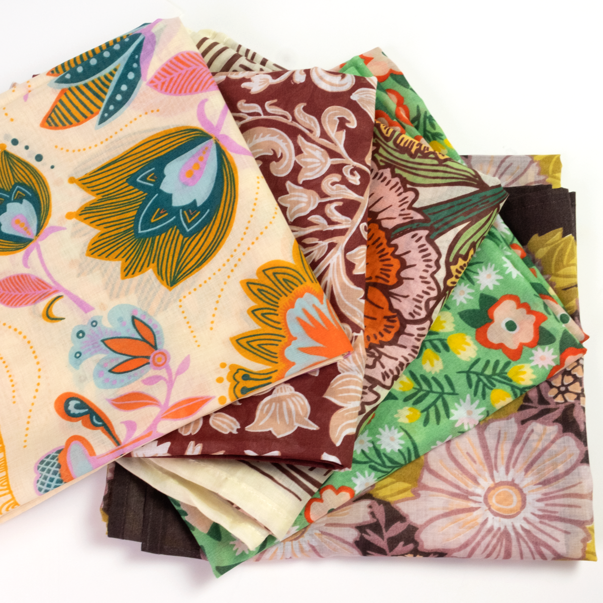 A stack of folded fabric bandanas with various colorful floral and paisley patterns.