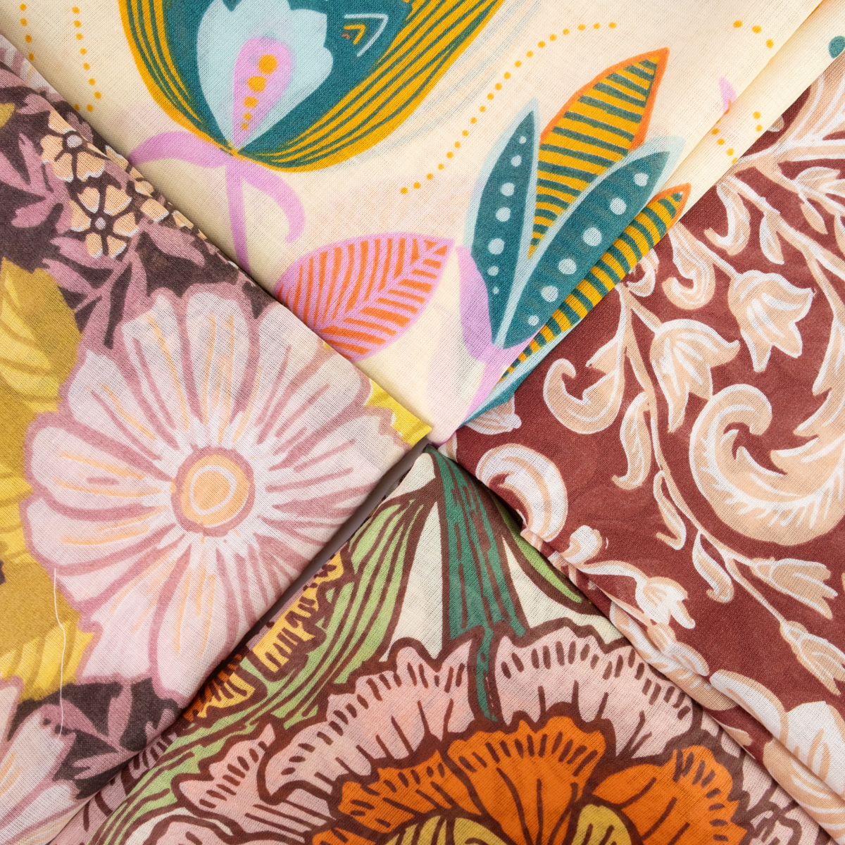 A close-up of folded cotton bandanas with retro vintage-style floral patterns in pink, orange, teal, brown, and cream.