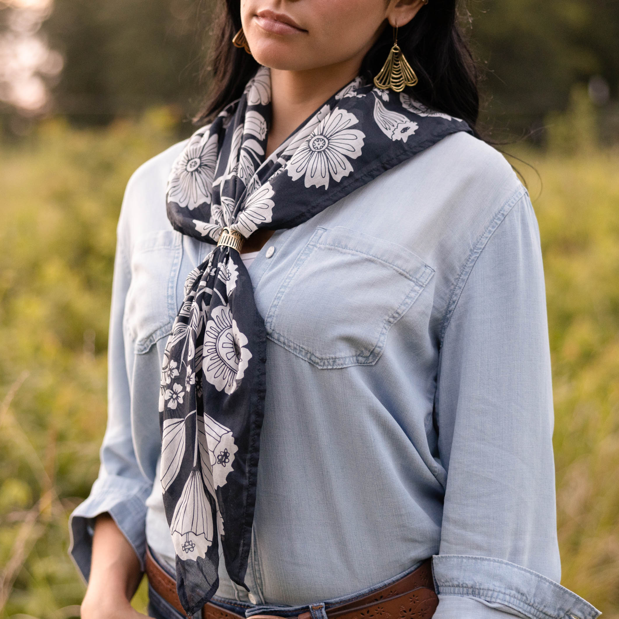 Woman in denim shirt with floral scarf outdoors