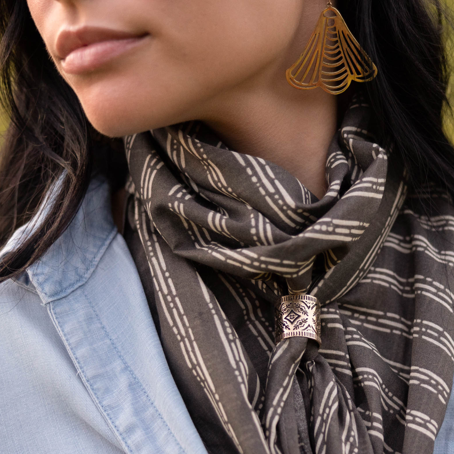 Person wearing a patterned scarf and dangling earring