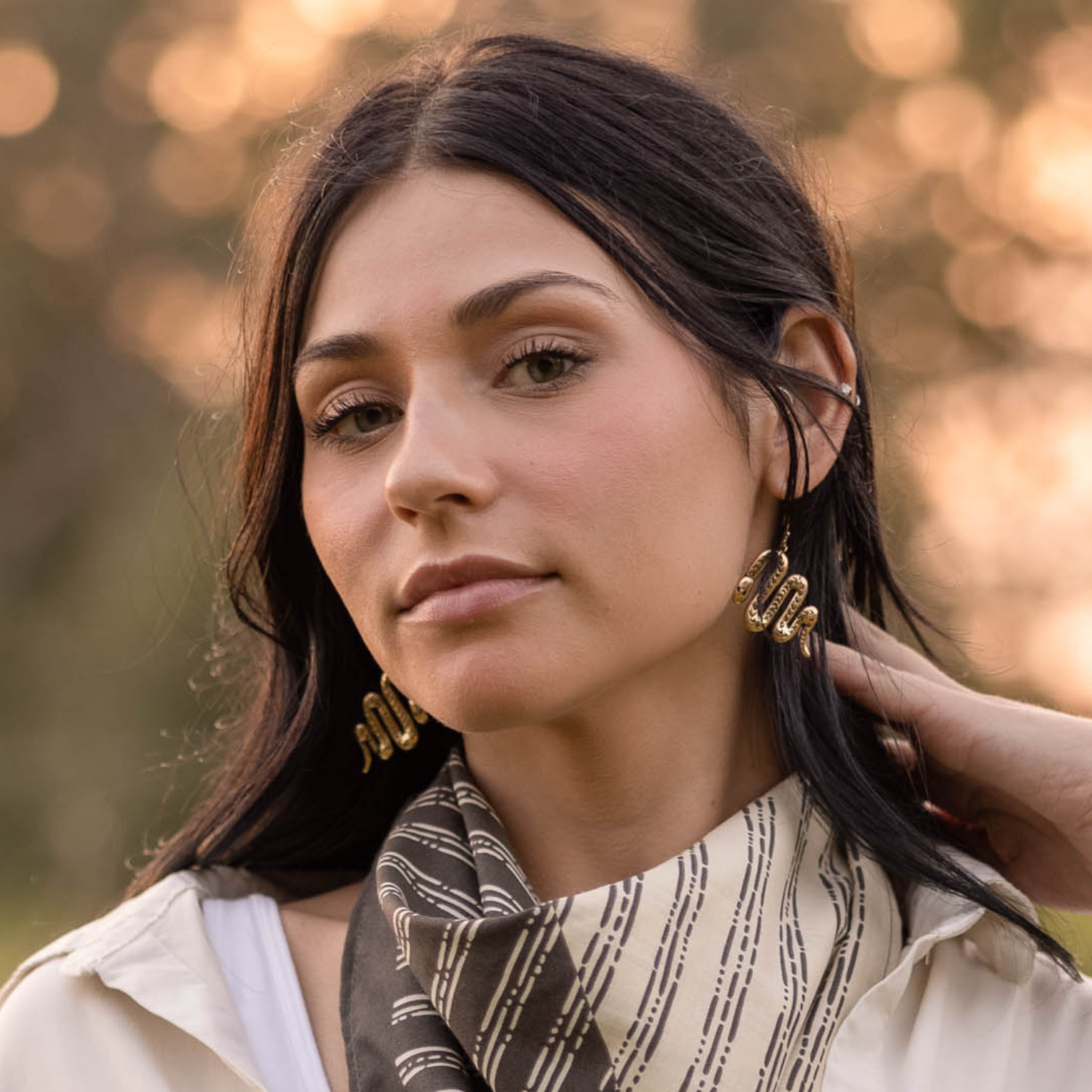 Woman in a patterned scarf with gold hoop earrings