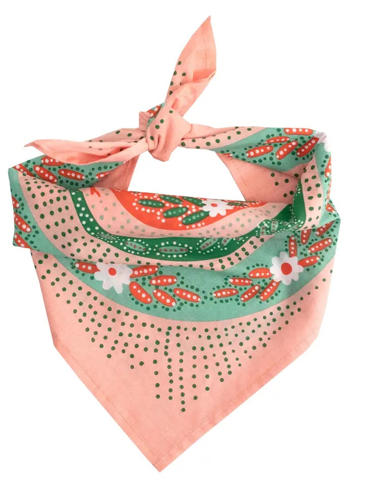 Folded front view of No. 069 Snakes pink bandana showing green and red snake-inspired print on light pink cotton