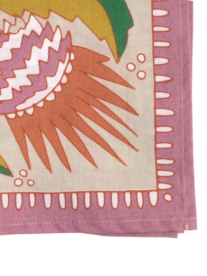 Close-up of No. 081 Martha cotton bandana showcasing corner stitching, orange floral motif on tan background and pink border
