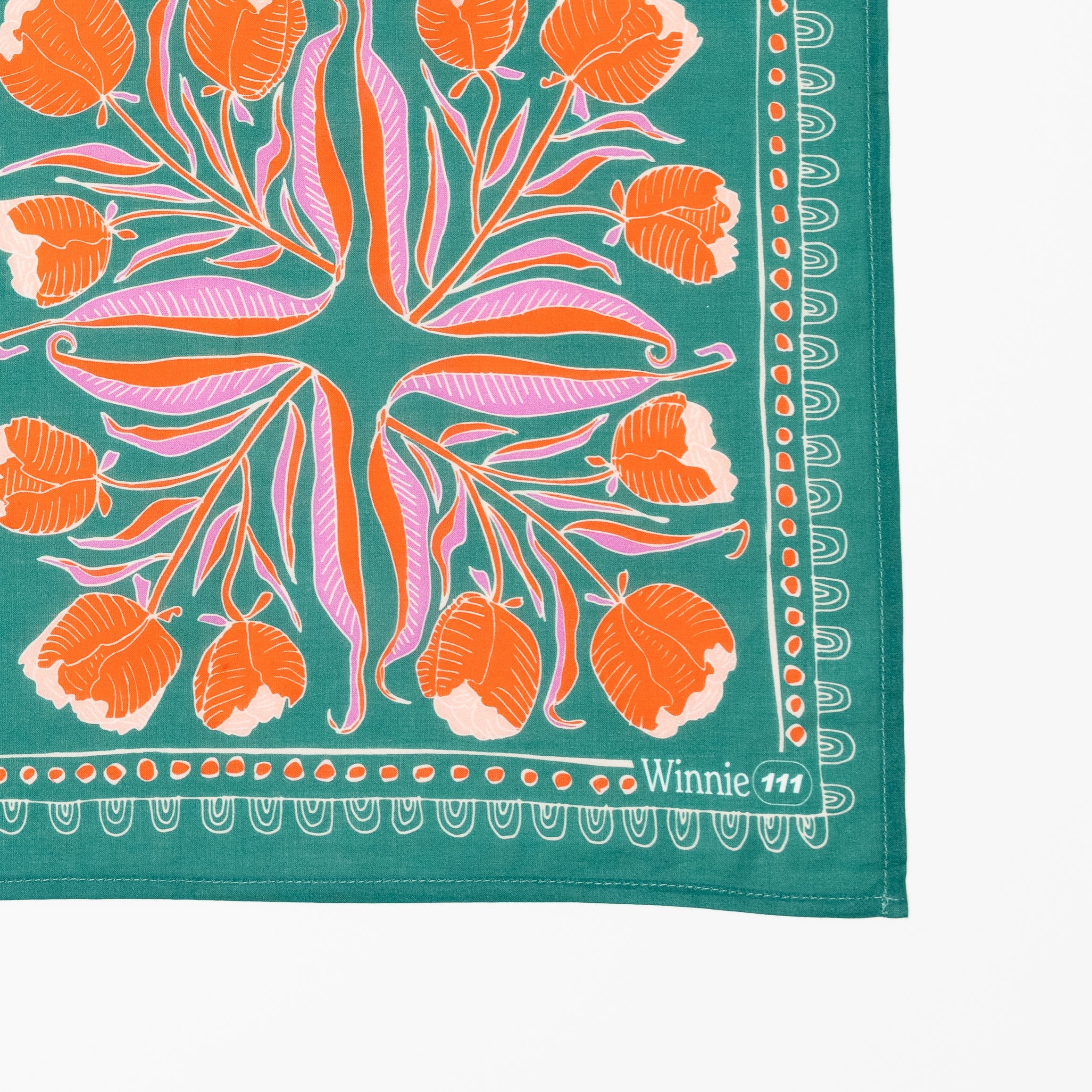 Floral patterned fabric with orange and pink flowers on a green background.