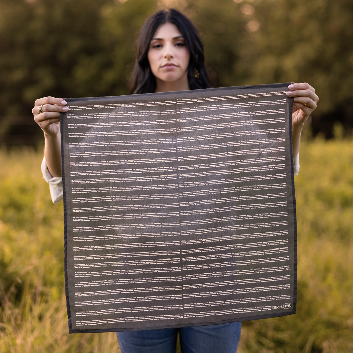 Person holding a patterned textile outdoors