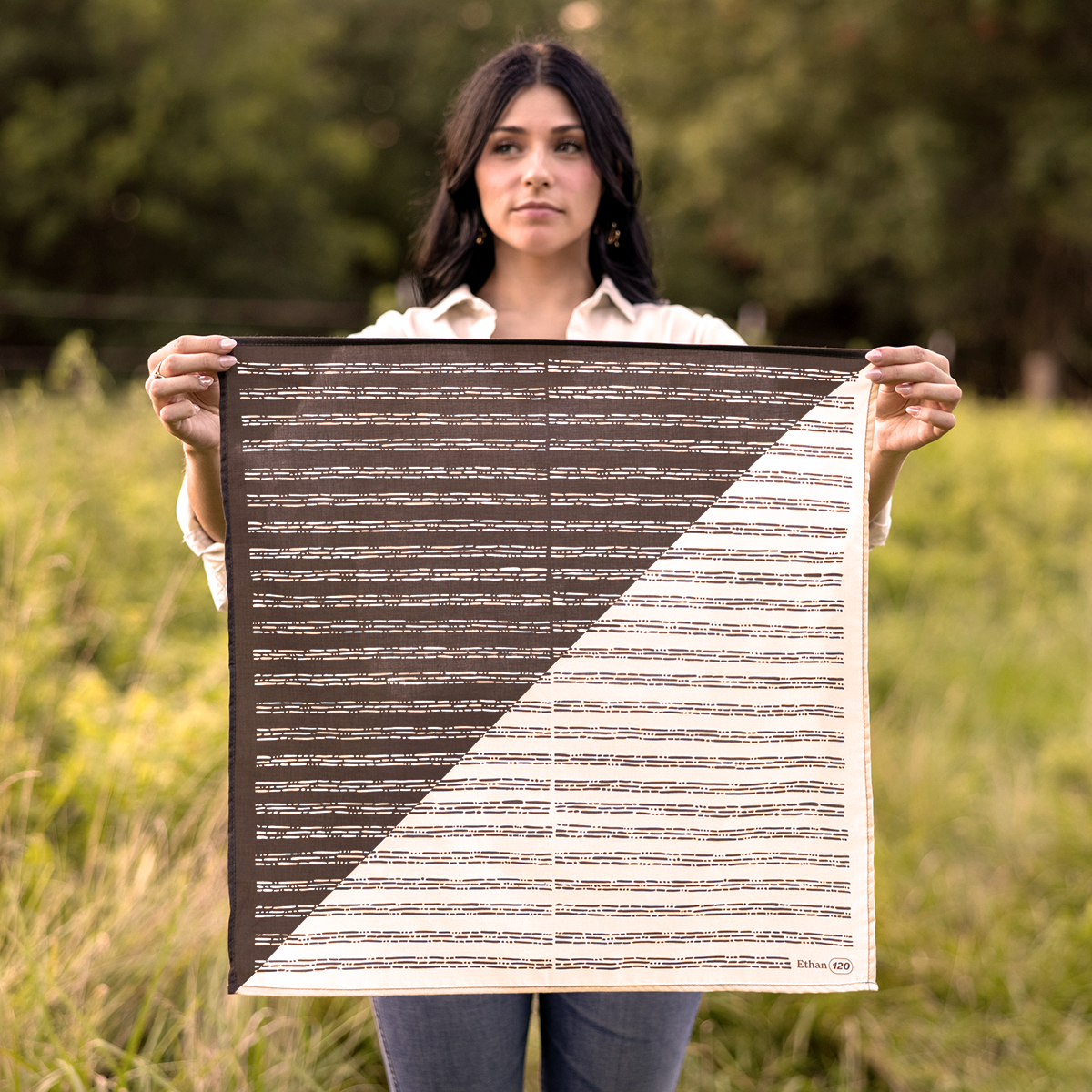 Person holding a patterned square scarf outdoors