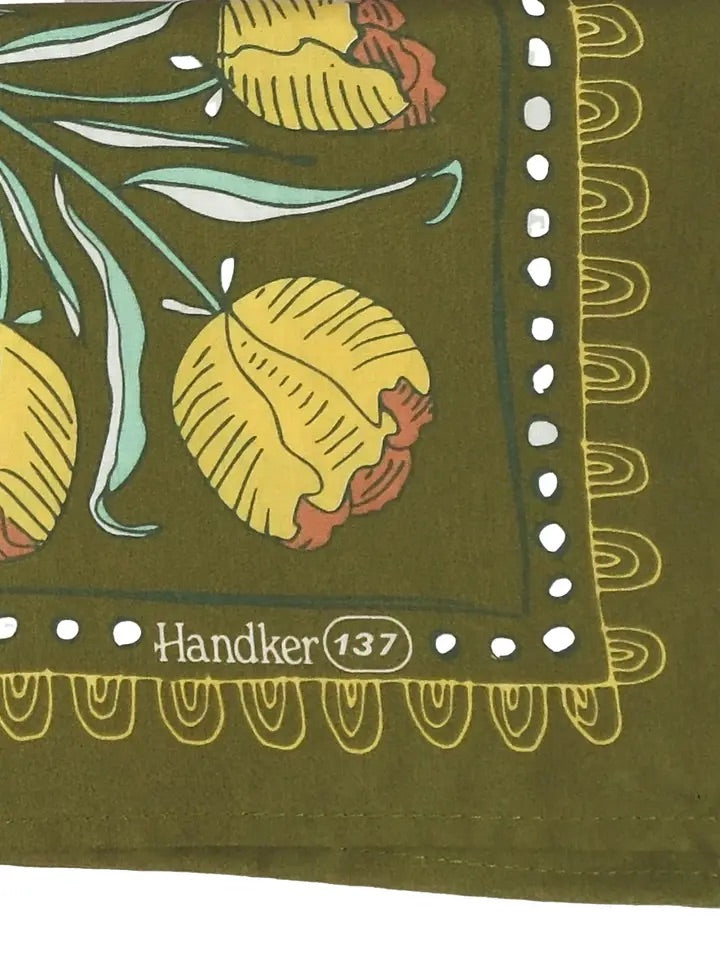 Close-up of Adele bandana, olive green with mustard and cream floral motifs, scalloped border and Handker 137 mark