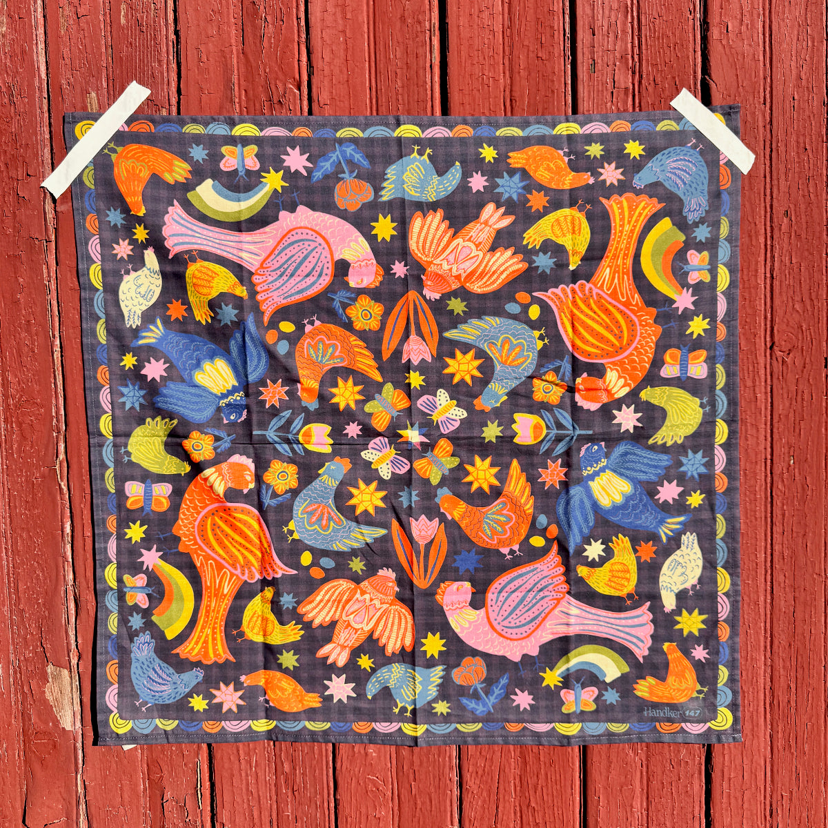 Colorful patterned bandana with birds and flowers on a wooden background