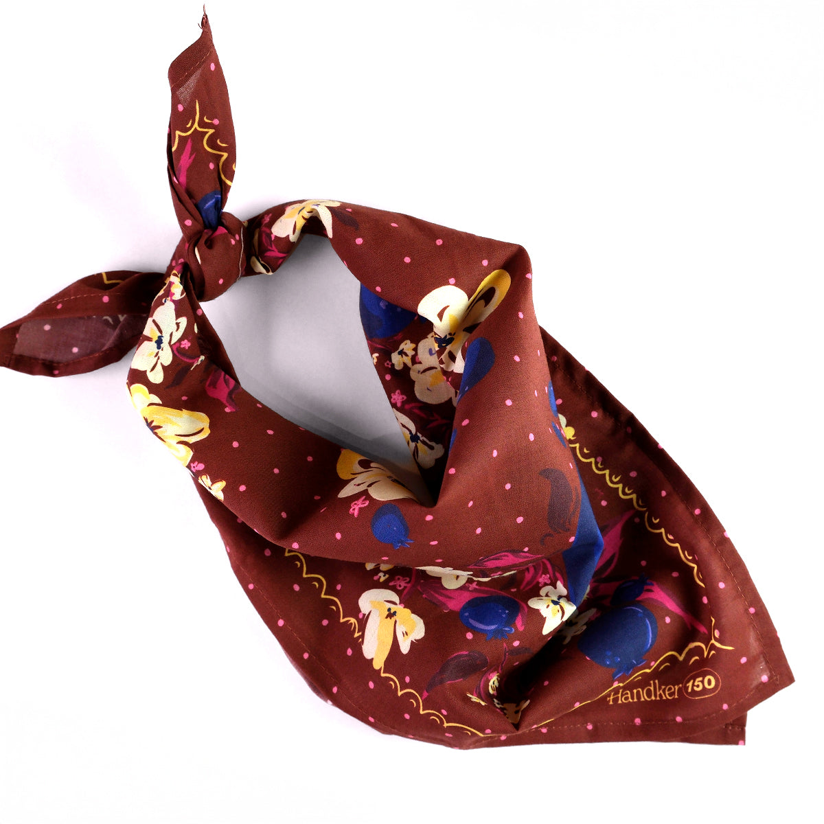 Floral patterned bandana with blueberries and yellow and pink flowers on a chocolate brown background, tied.