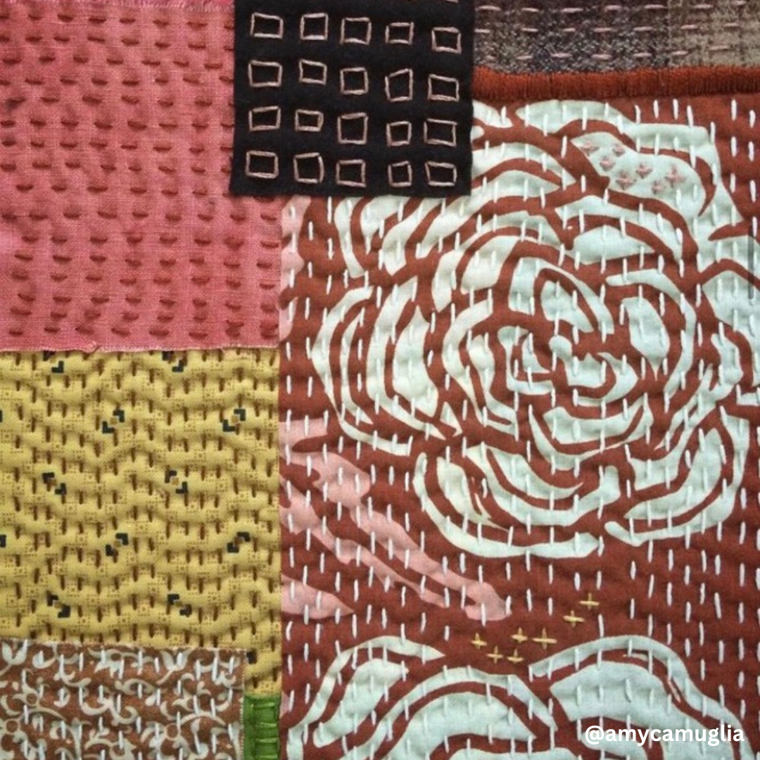Close-up of hand-stitched patchwork quilt showcasing colorful fabric squares with visible running-stitch texture