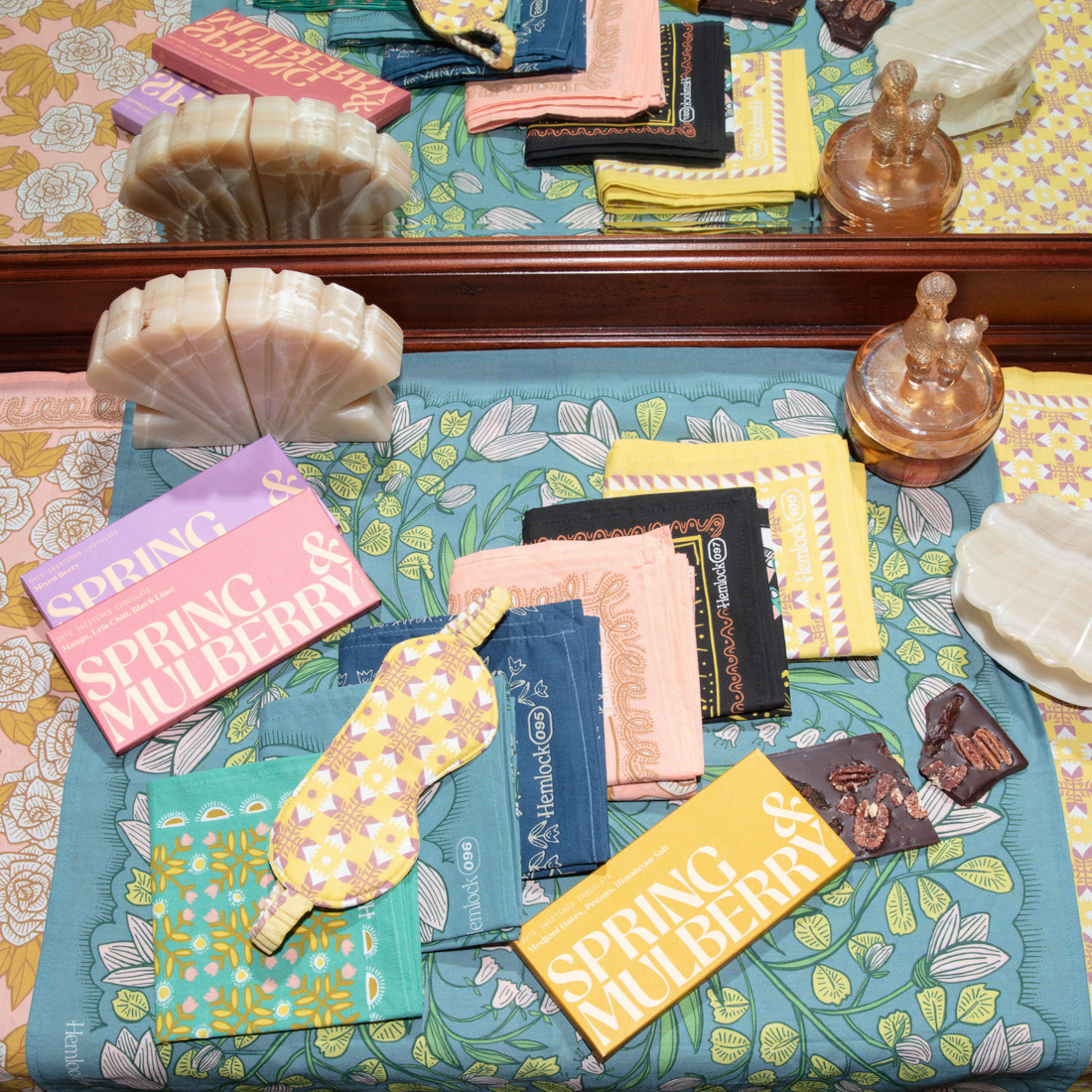 Arrangement of Spring & Mulberry chocolate bars and assorted items on a floral tablecloth
