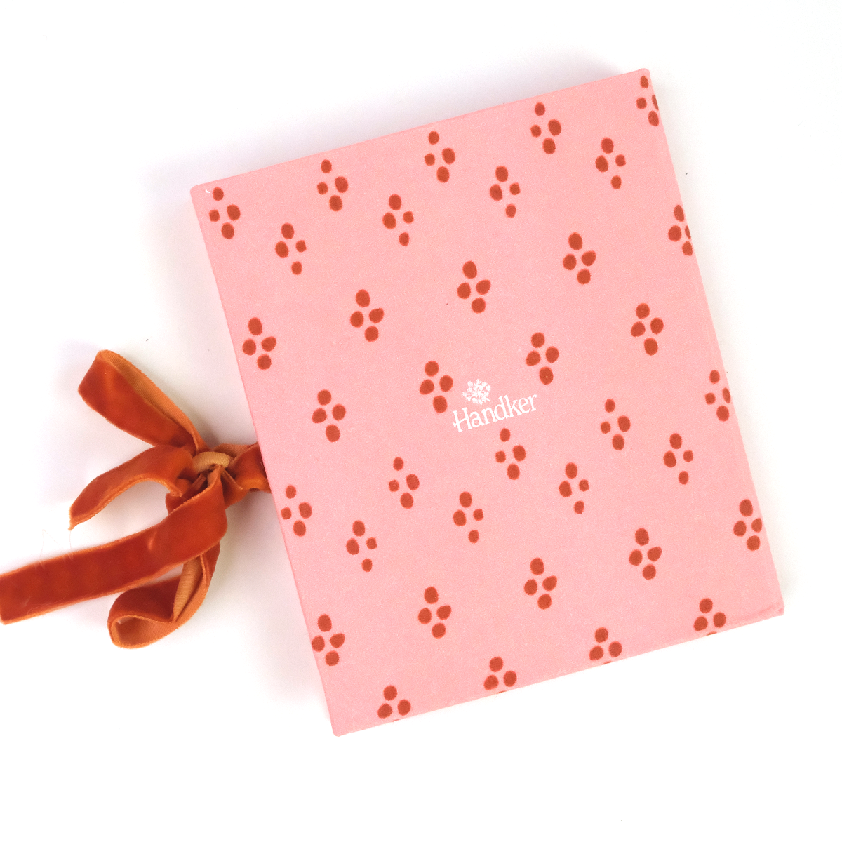 Handker closed photo folio album with pink and red patterned design, tied closed with a red orange velvet ribbon
