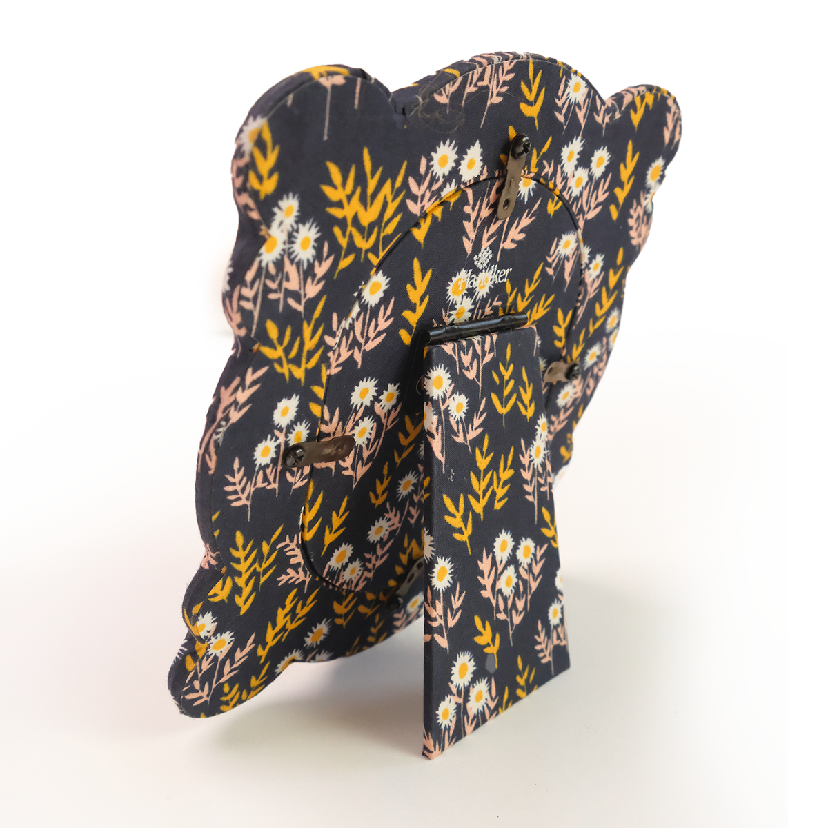 Back of standing fabric tabletop frame with nostalgic navy, pink, and yellow floral pattern
