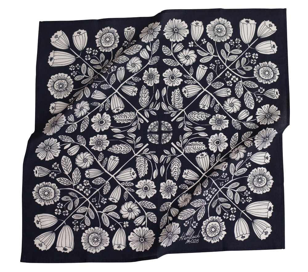 Floral patterned fabric with intricate white designs on a dark background.