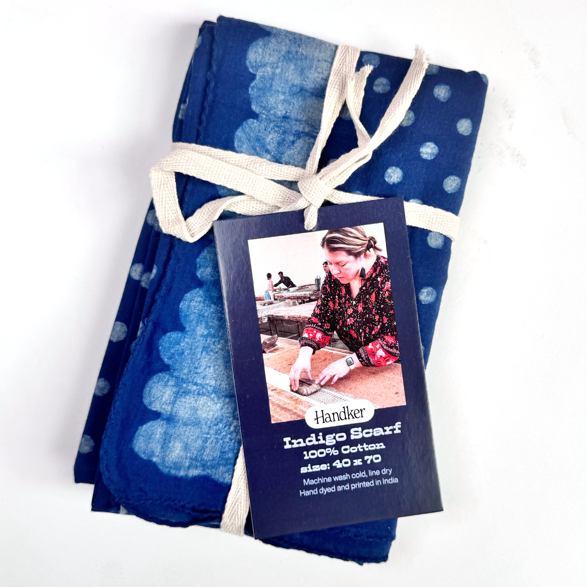 Folded view of Laken indigo-dyed cotton scarf showcasing blue-and-white resist pattern, tied with a cream ribbon