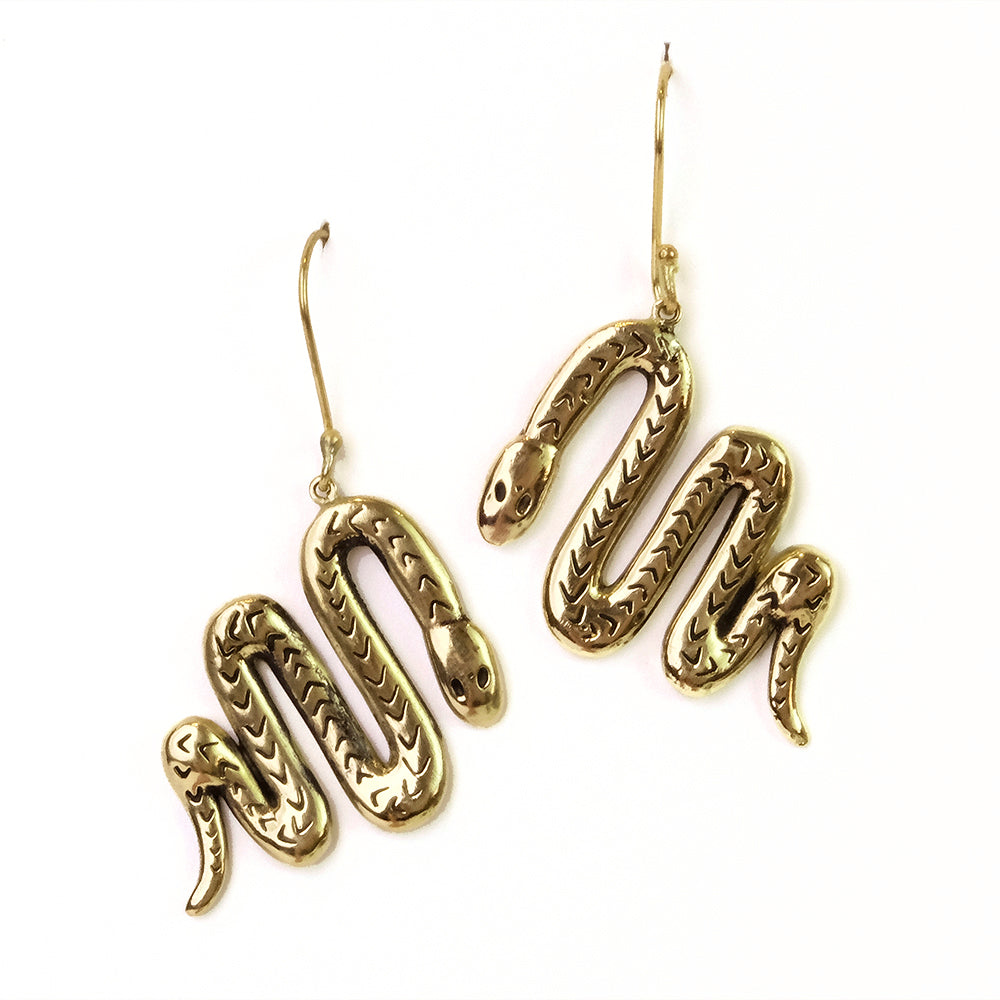 Gold snake-shaped earrings on a white background.