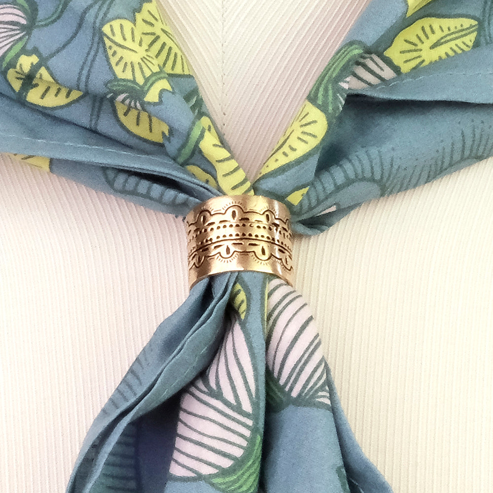 Close-up of a blue patterned scarf  bandana, bandanna, or handkerchief with a decorative metal ring