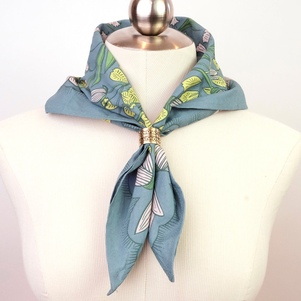 Blue floral scarf with a gold ring on a mannequin