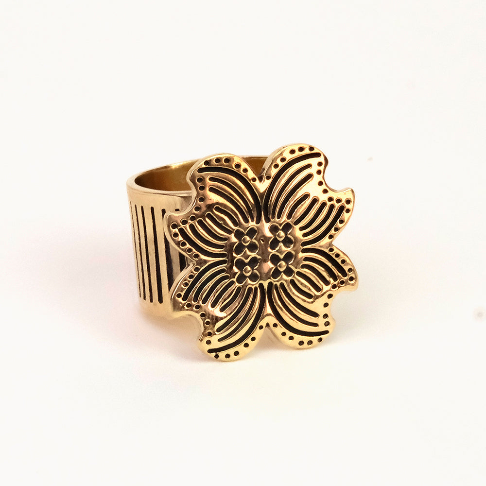 Gold-tone floral statement ring with wide ribbed band and ornate flower top.