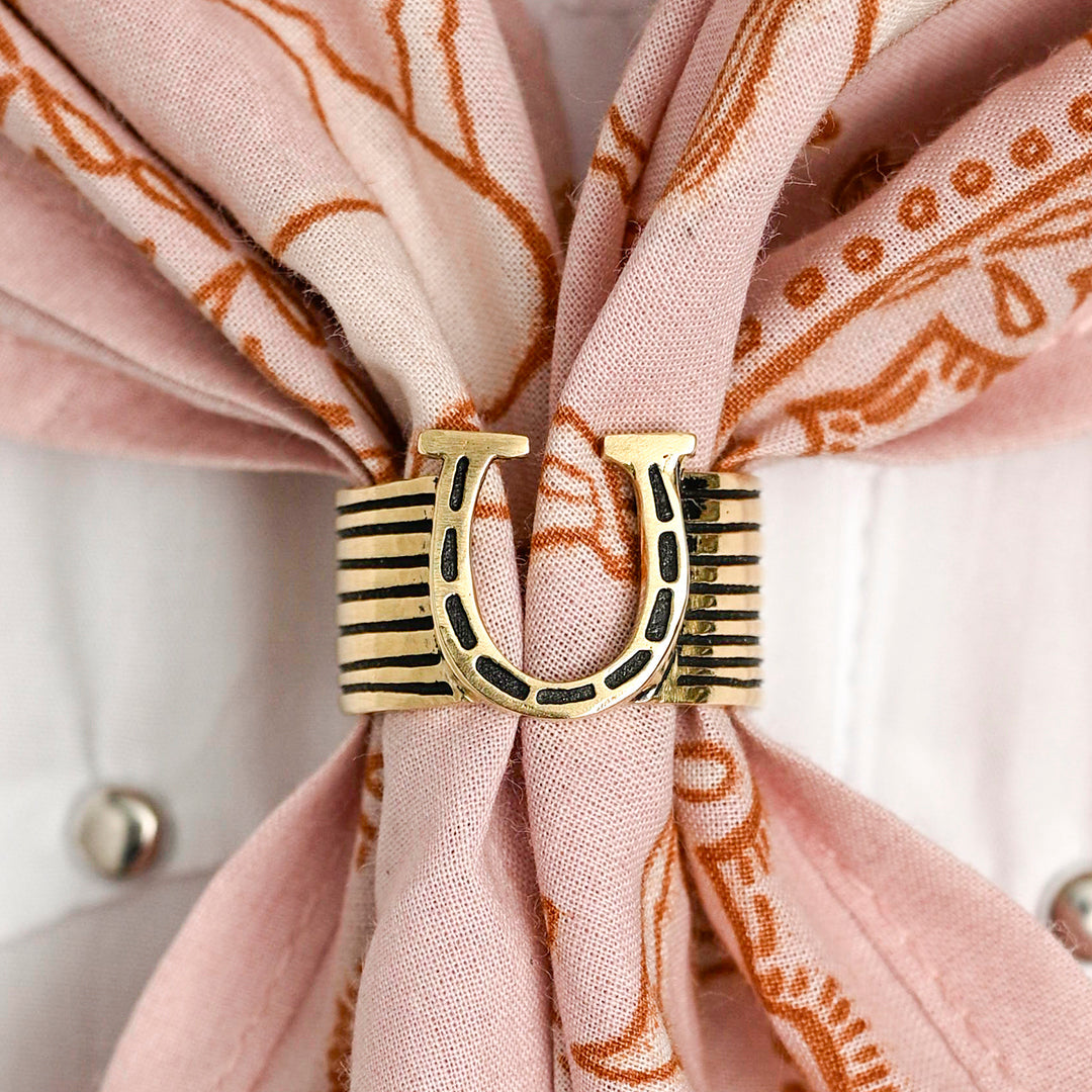Gold-tone striped scarf ring securing a pink patterned silk scarf