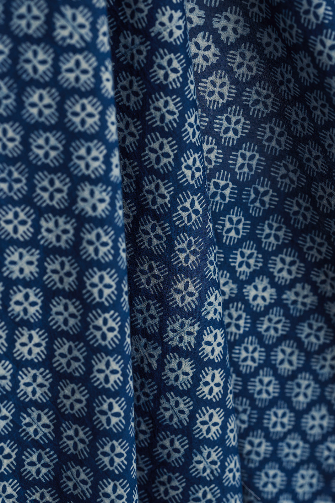 Close-up of Laken indigo-dyed cotton scarf showcasing gauzy drape and white Dabu mud-resist geometric floral print