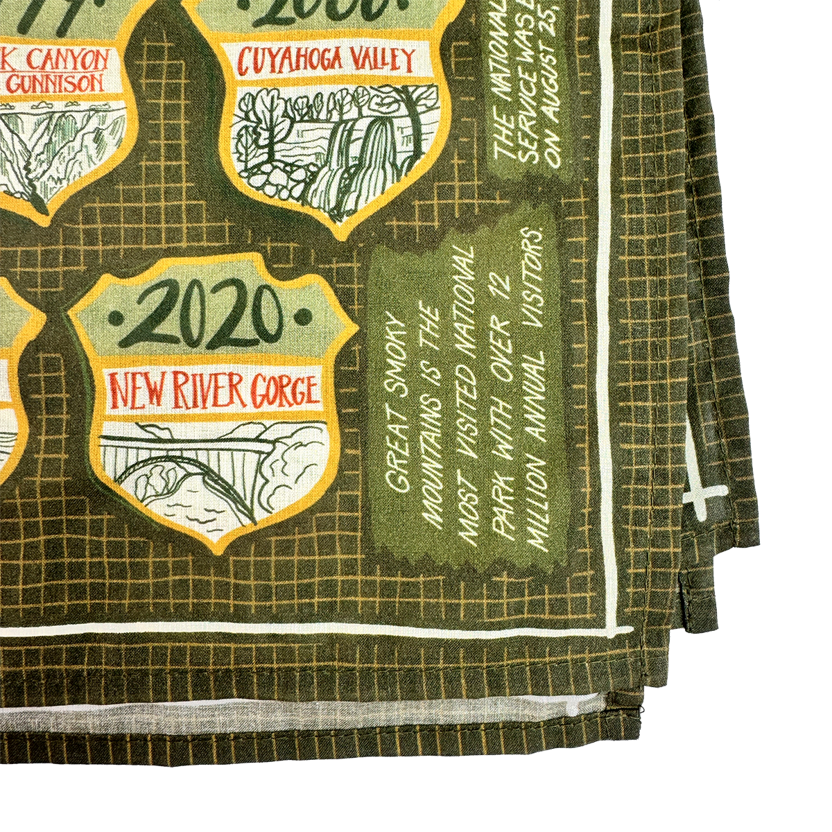 Green fabric with embroidered patches and text, featuring scenic national parks designs 