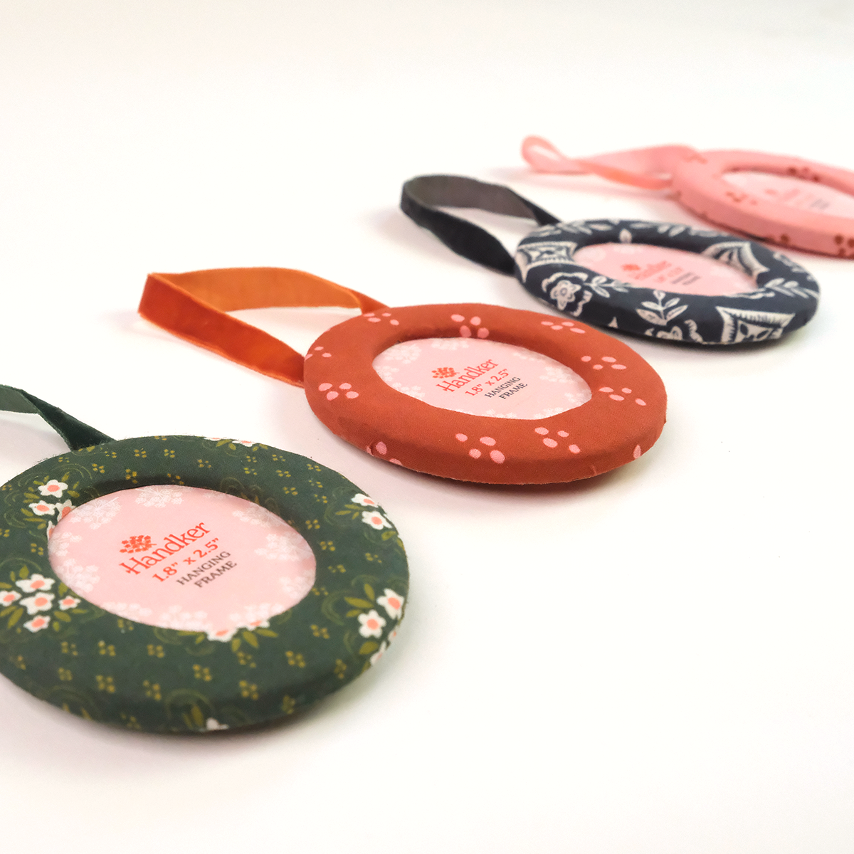 Four colorful fabric ornament photo frames with velvet ribbons for hanging