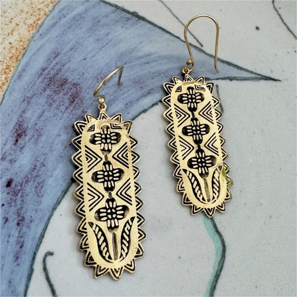 Pair of decorative rectangular earrings with intricate black patterns