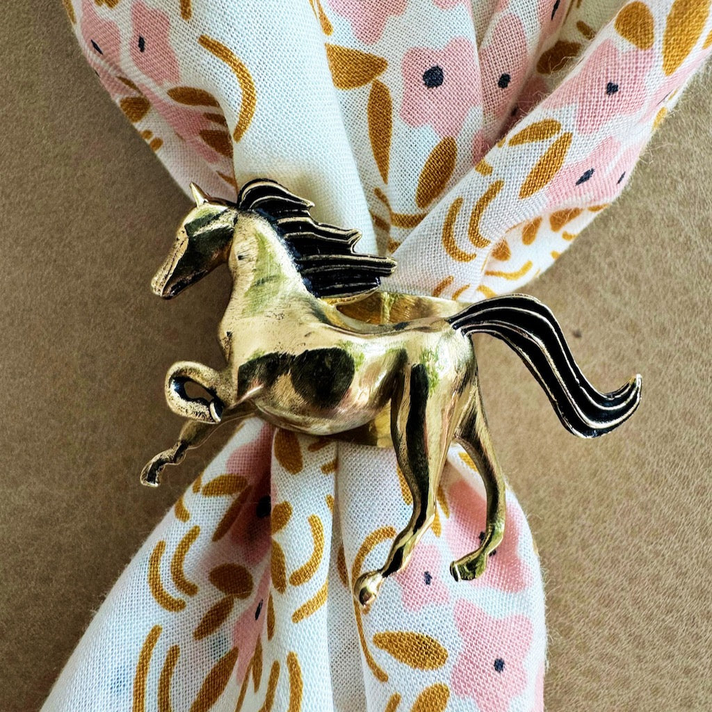 Gold-tone horse scarf ring securing a pink-and-white floral scarf