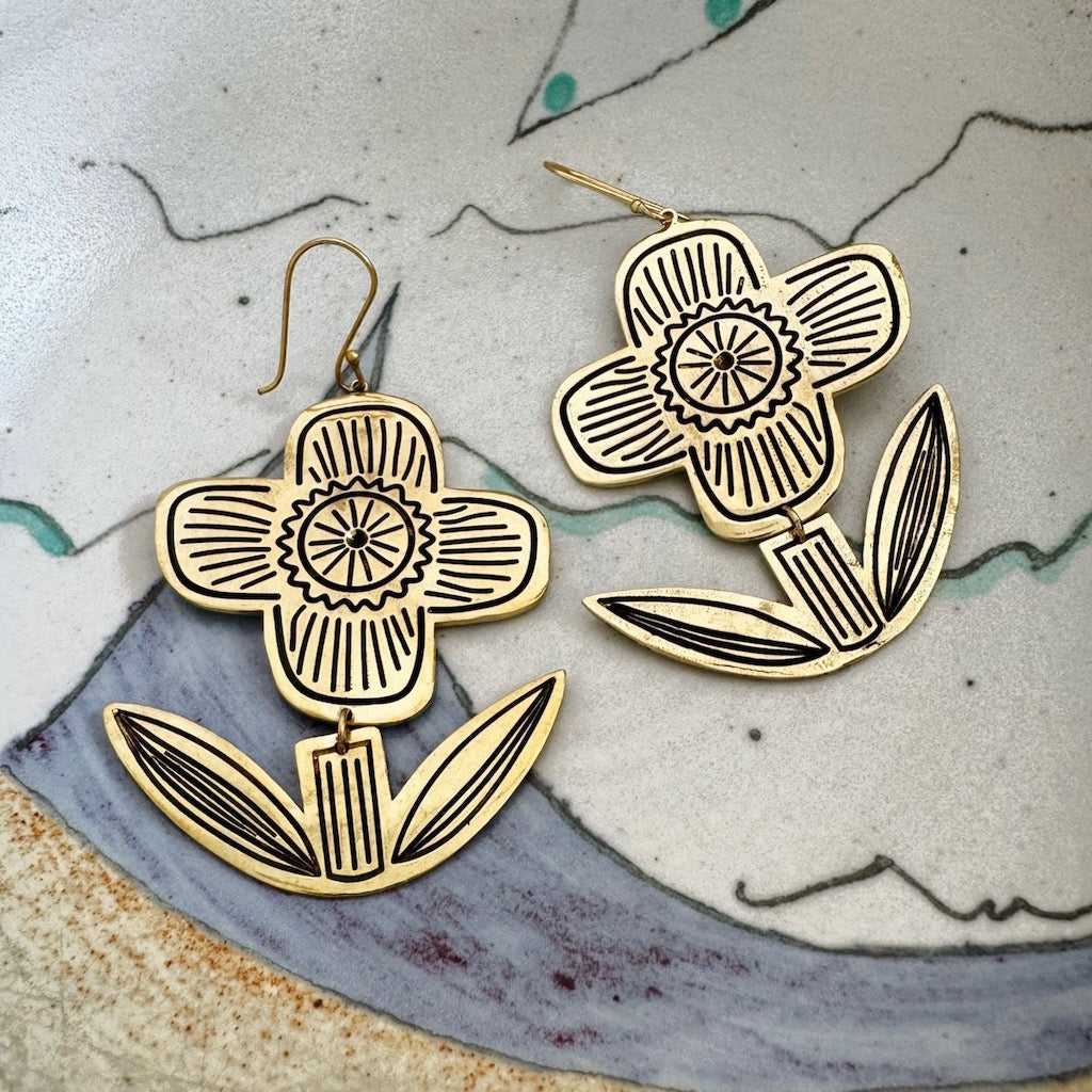 Floral design earrings on a ceramic surface