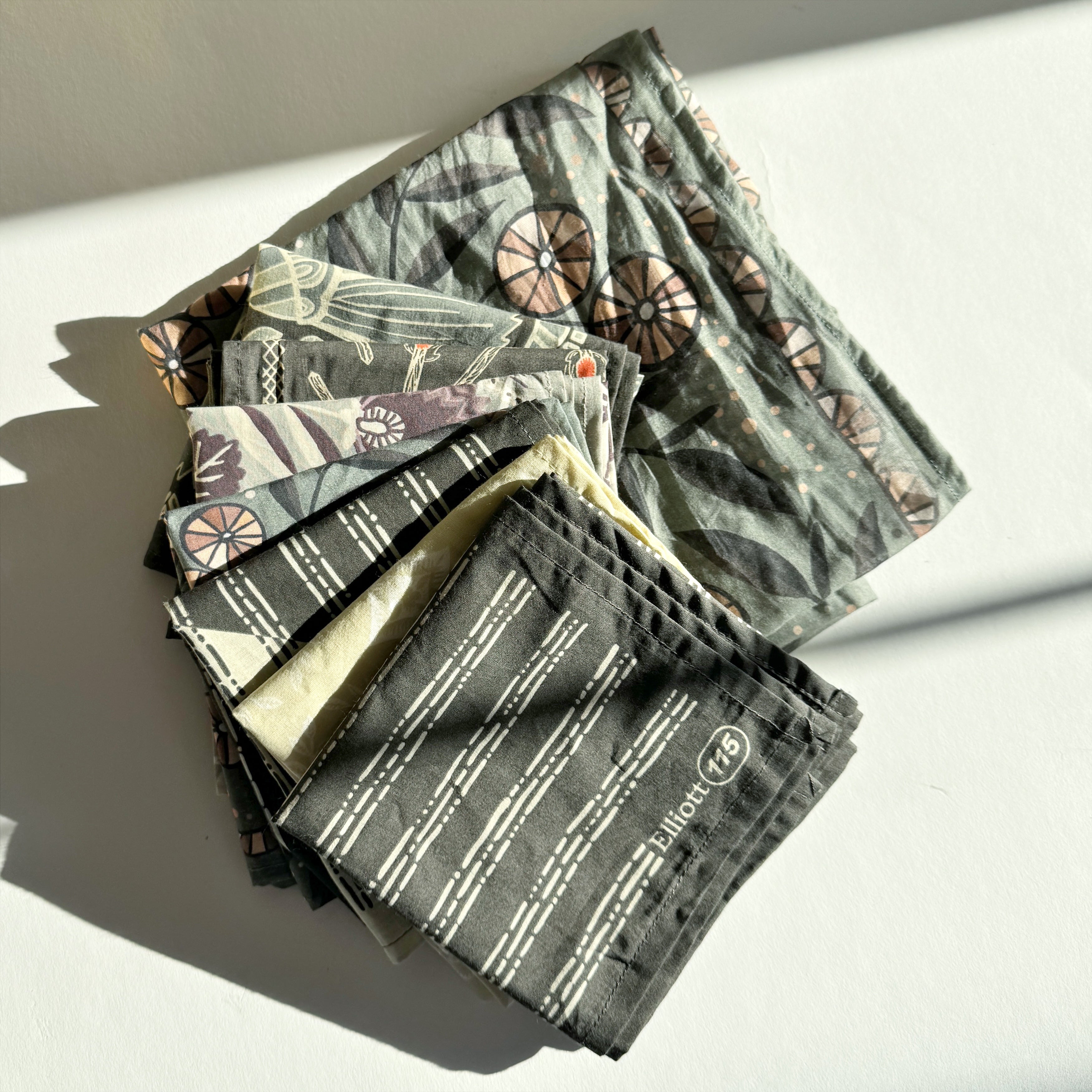 Stack of folded patterned cloths on a white surface