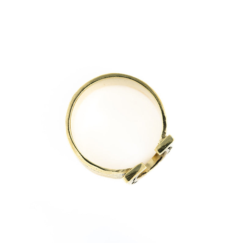 Gold signet ring, top-down view with blank oval face and decorative band