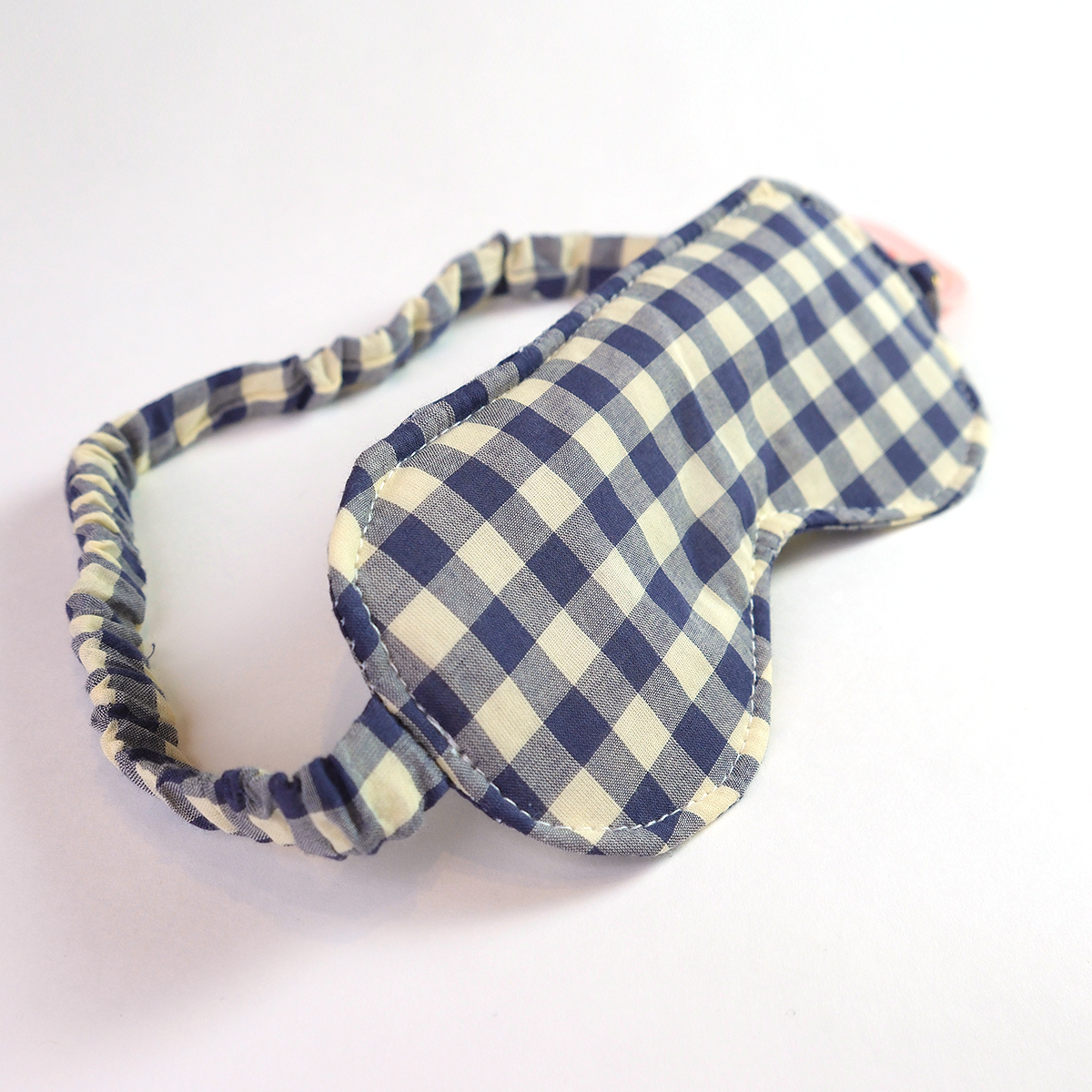 Blue and white checkered eye mask on a white background