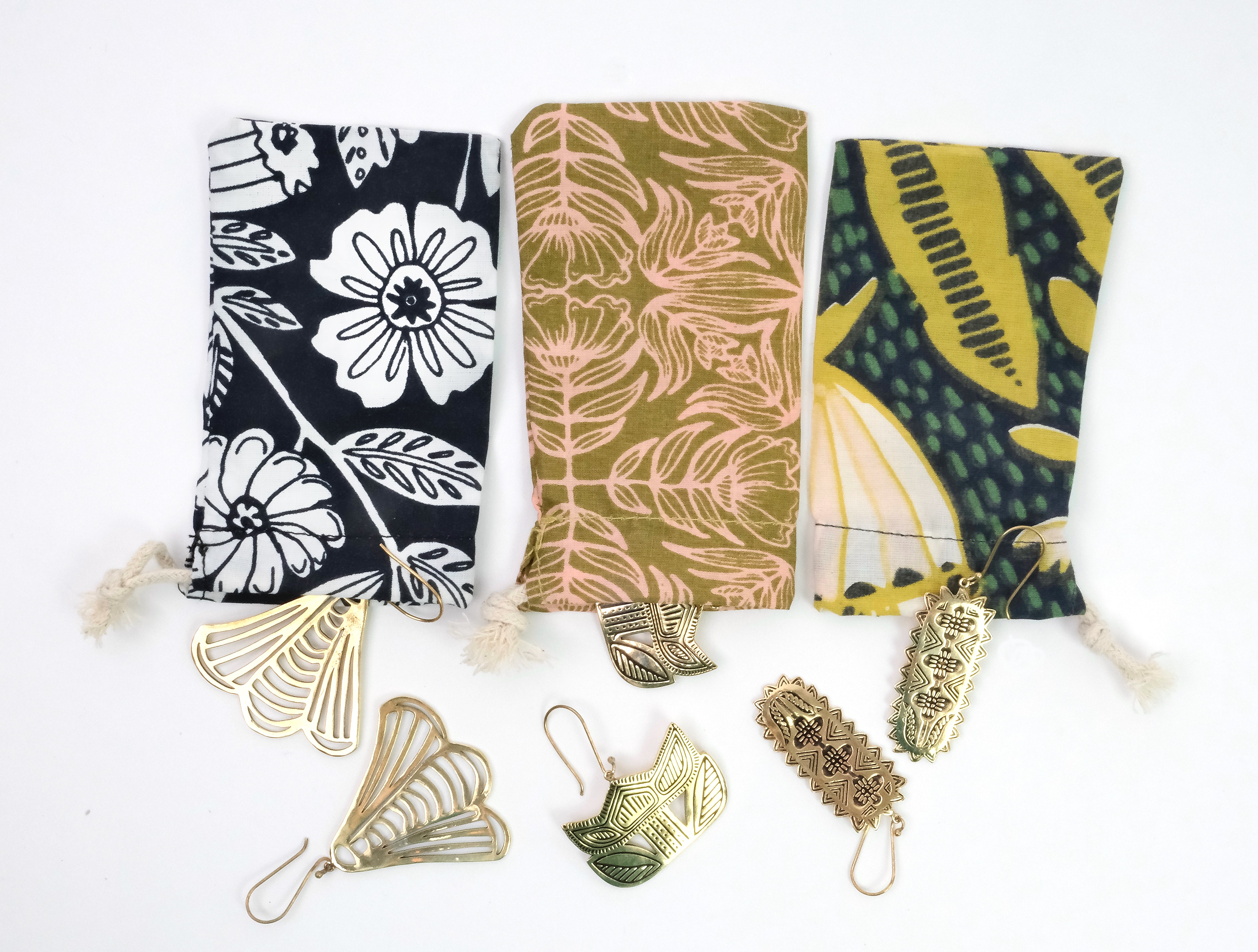 Three patterned fabric pouches with decorative metal hooks on a white background.