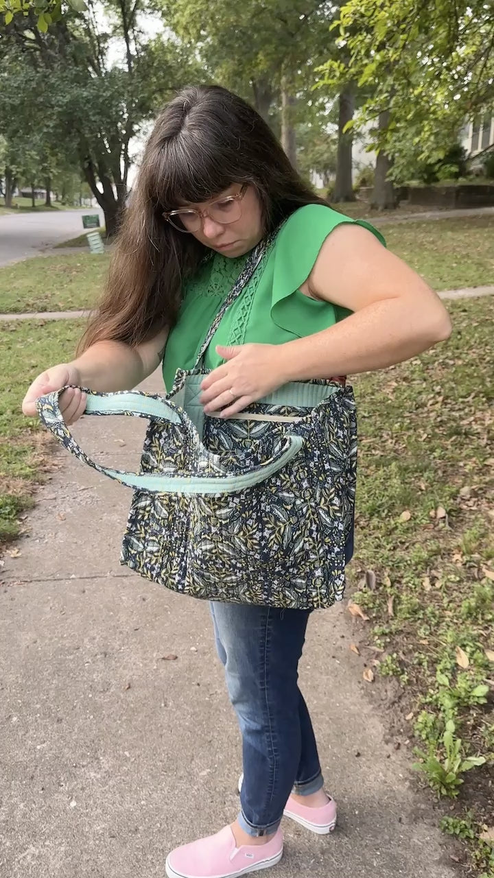Video of a girl looking inside her blue floral-patterned bag and unzipping the interior pocket