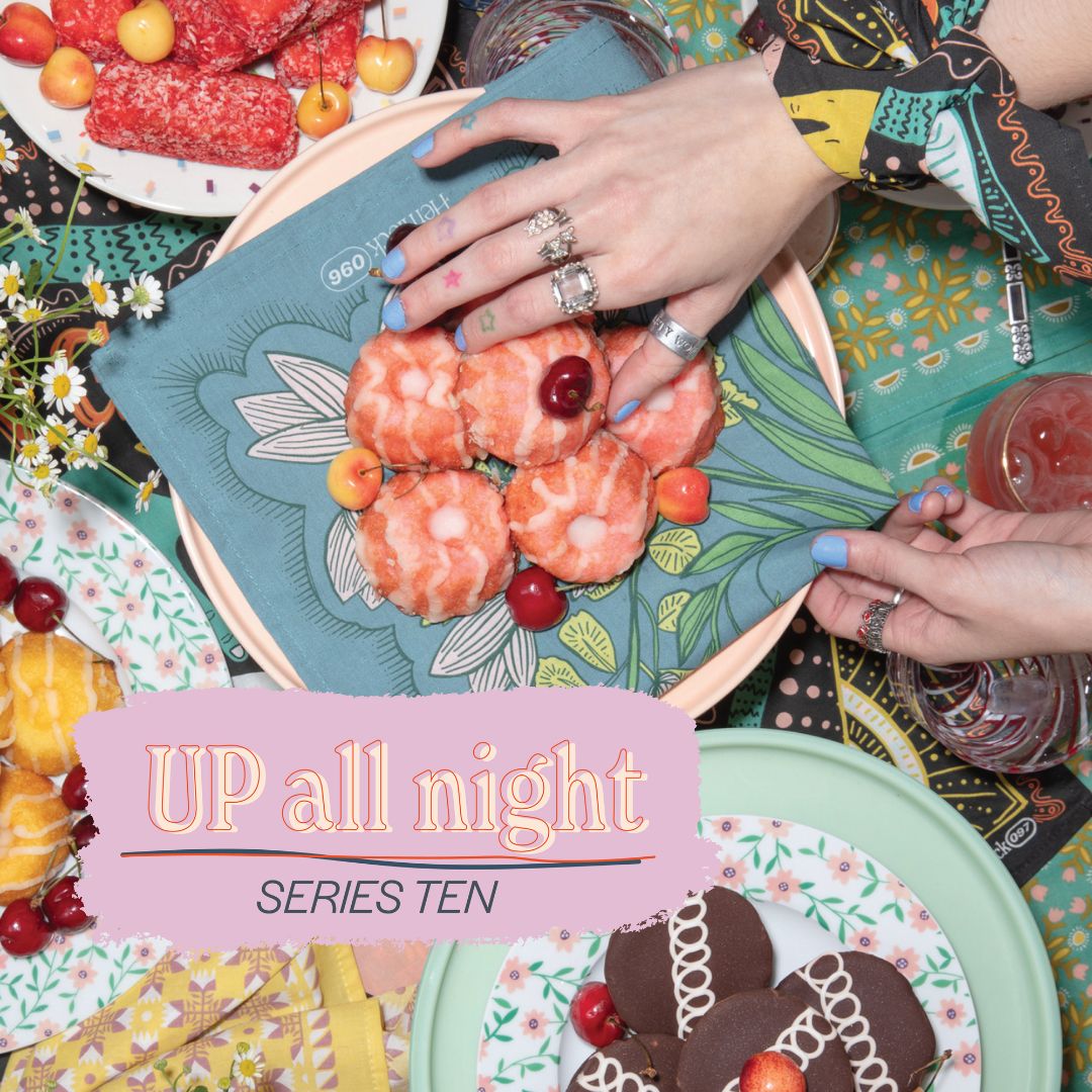 Teal-green Handker bandana with stylized white flowers used as napkin under pink-glazed mini bundt cakes